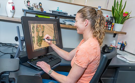 A Redland designer working on a landscape plan using a computer.